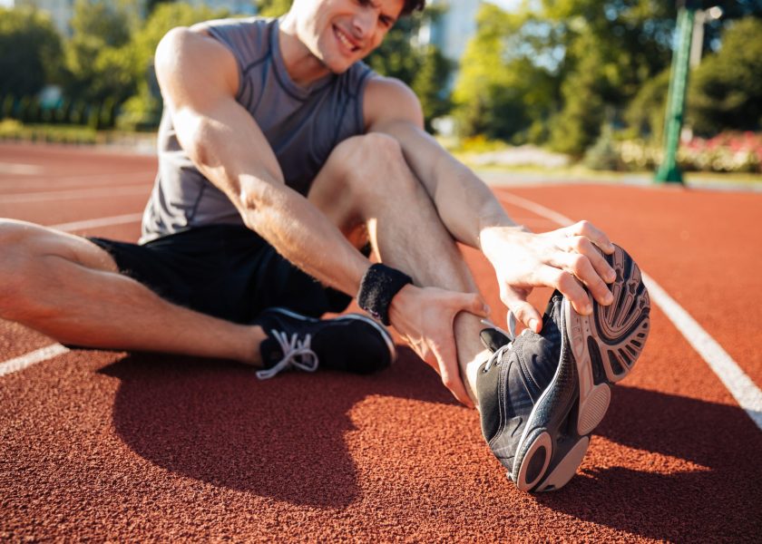 Cropped image of a runner suffering from leg cramp